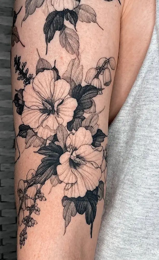 a woman's arm with black and white flowers on it