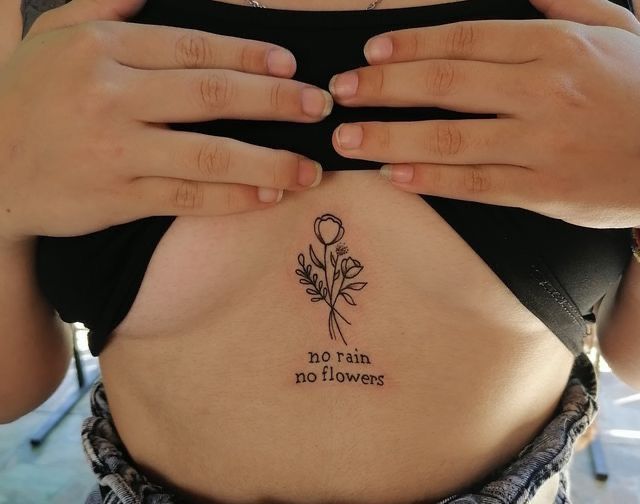 a woman with a flower tattoo on her stomach and the words no rain, no flowers