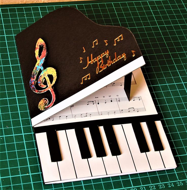 a birthday card sitting on top of a piano keyboard with music notes and musical notes