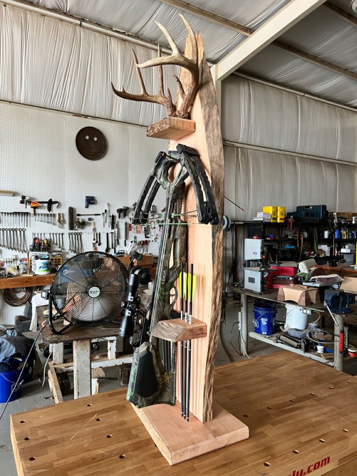 a large wooden sculpture with antlers on it's head and legs in a workshop