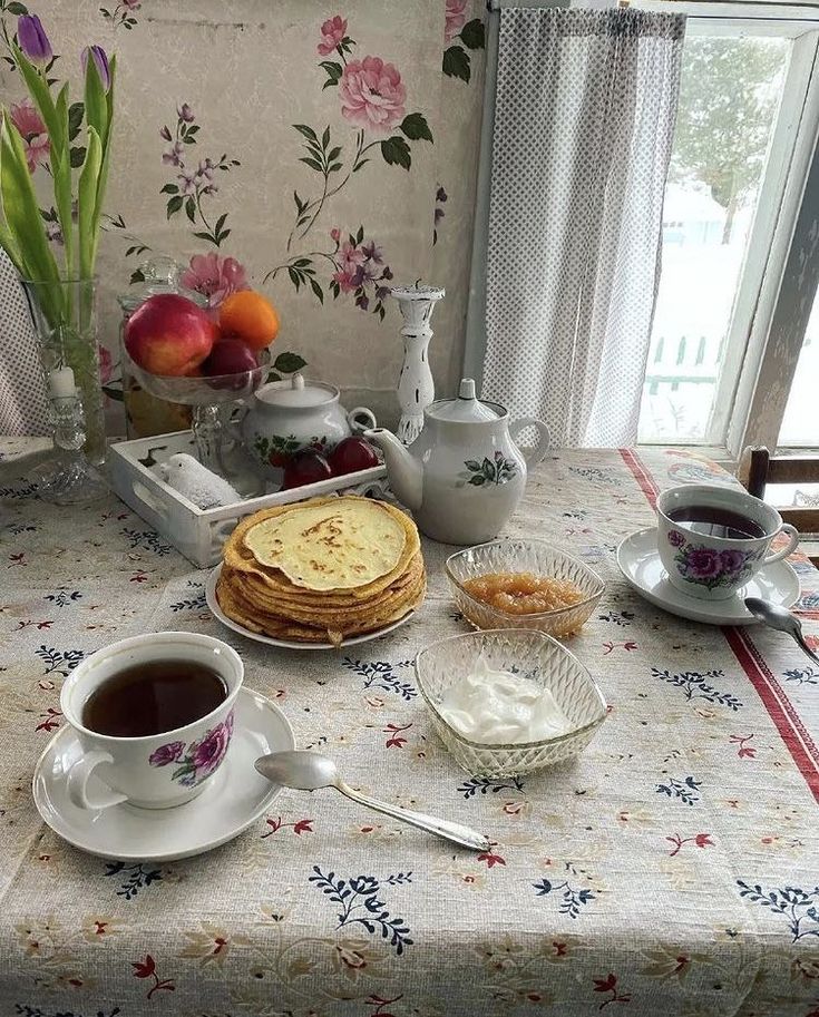 a table topped with plates of food and cups of coffee