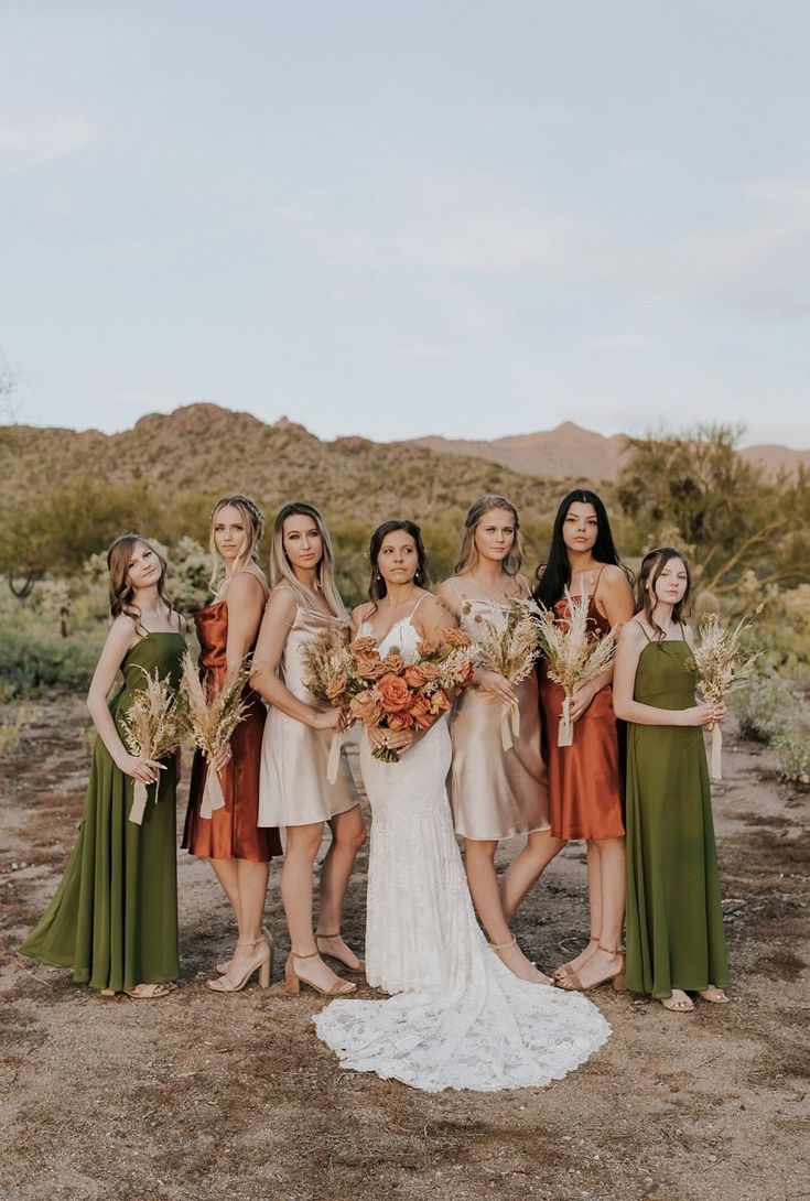 a group of women standing next to each other in front of a desert landscape with flowers