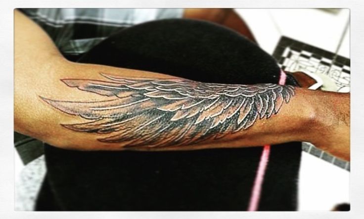 a man with a wing tattoo on his arm