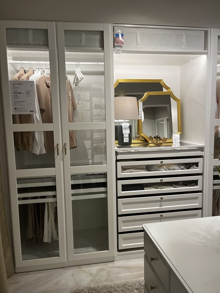 a white closet with mirrored doors and drawers