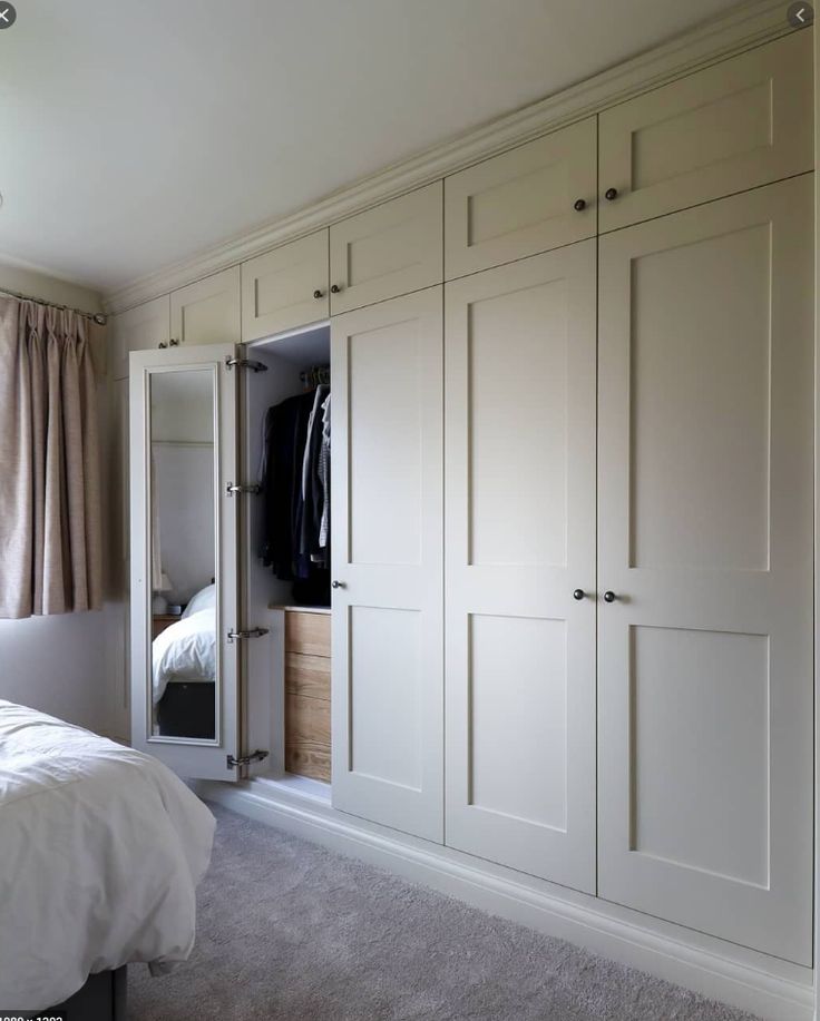 a bedroom with white closets and carpeted flooring