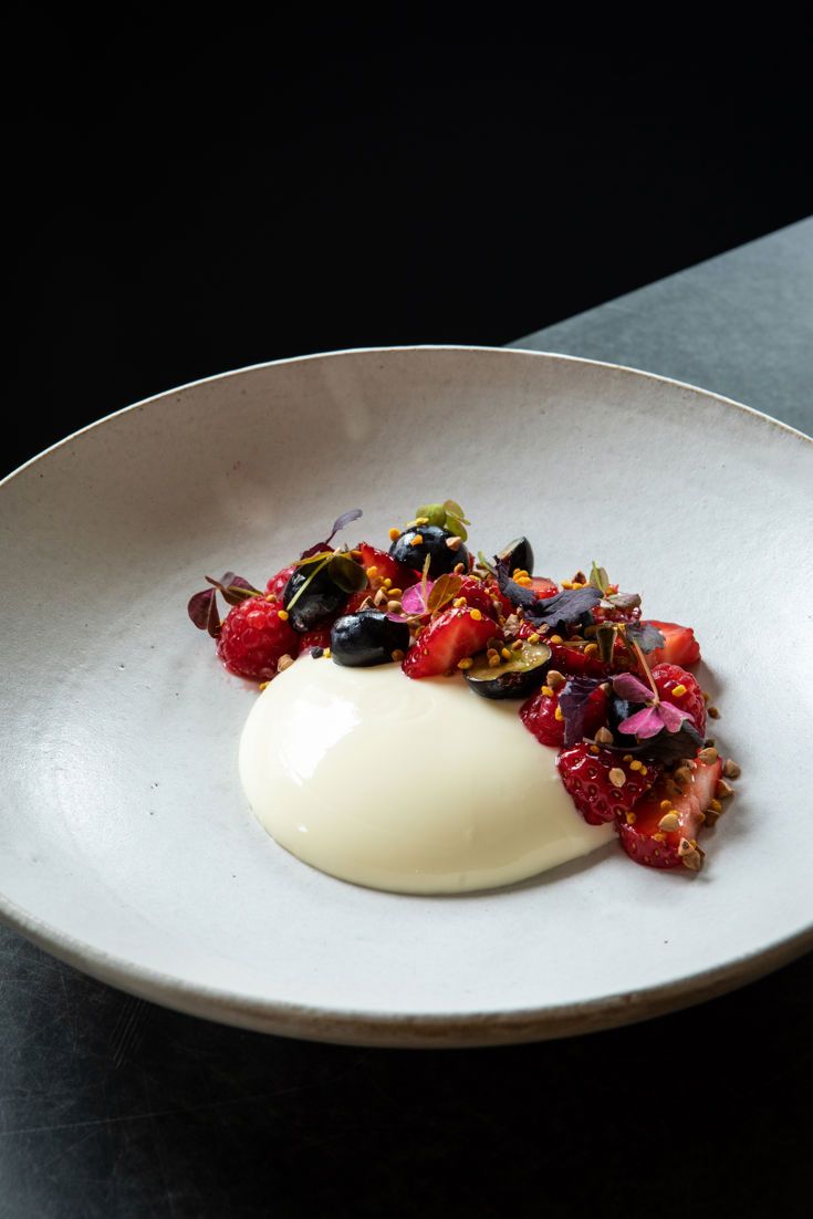 a white plate topped with an egg covered in fruit