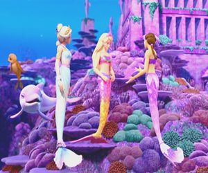 three mermaids are standing in front of a castle with pink and purple decorations on it