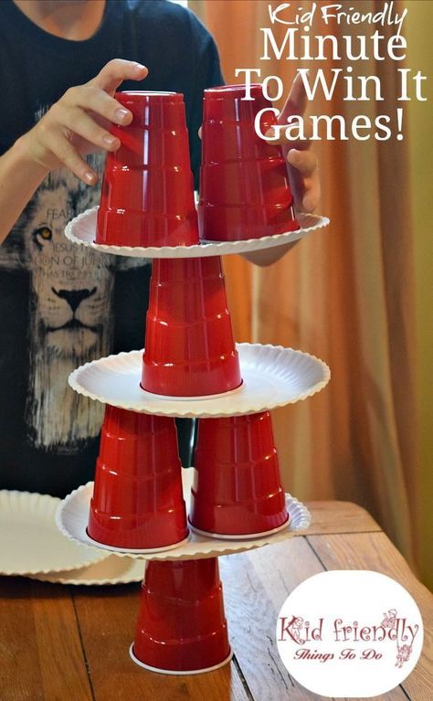 a young boy is playing with three red cups that are stacked on top of each other