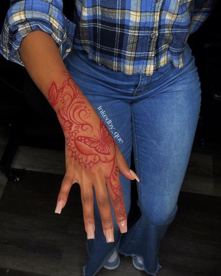 a woman's hand with red henna on it