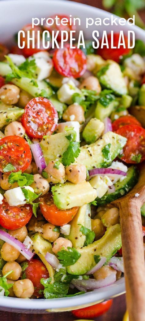 a salad with chickpea, tomatoes and cucumber in a white bowl