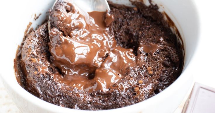 a white bowl filled with chocolate pudding and a spoon