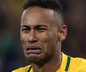 a soccer player wearing a yellow shirt and looking to his left with an angry look on his face