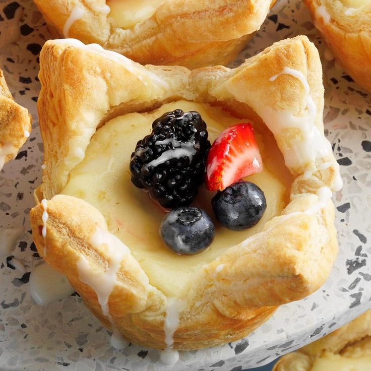 several pastries with berries and cream on them