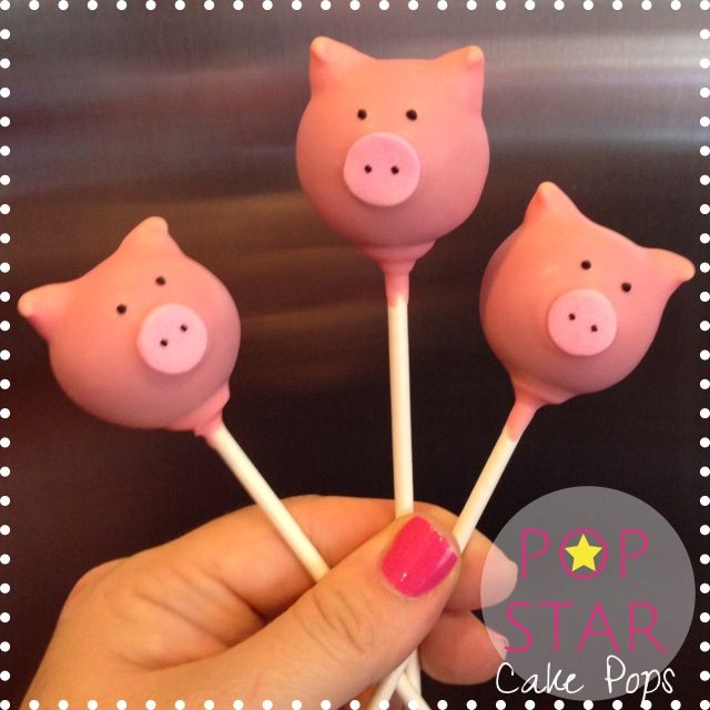 three pink pig lollipops sitting on top of each other