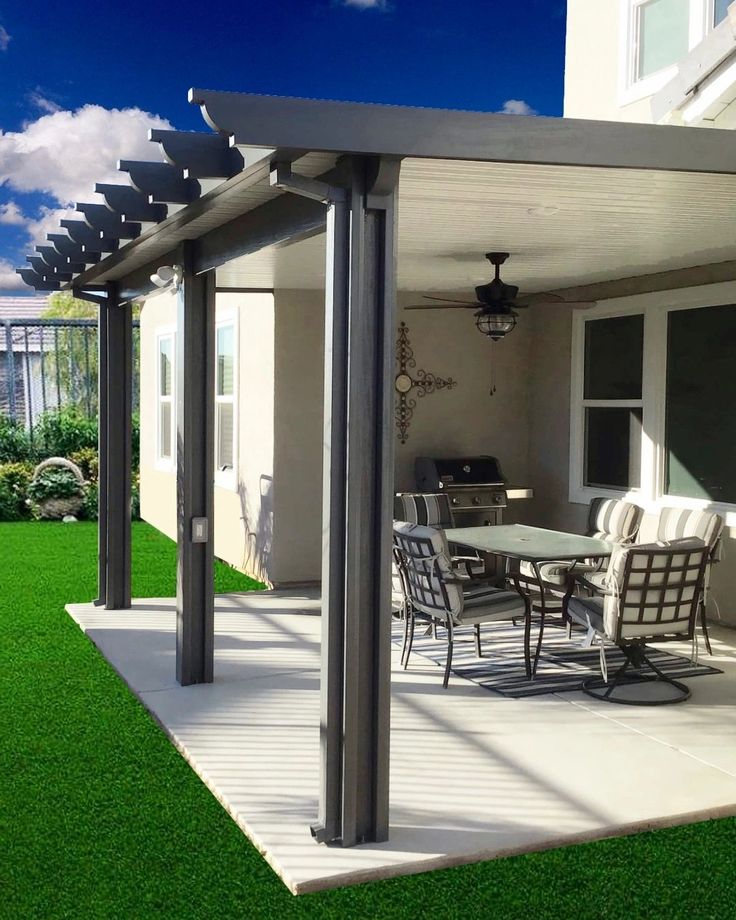 an outdoor dining area with grass and patio furniture