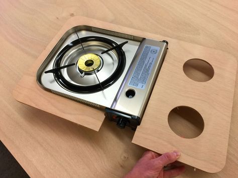 a person is working on a stove that has been made out of plywood planks