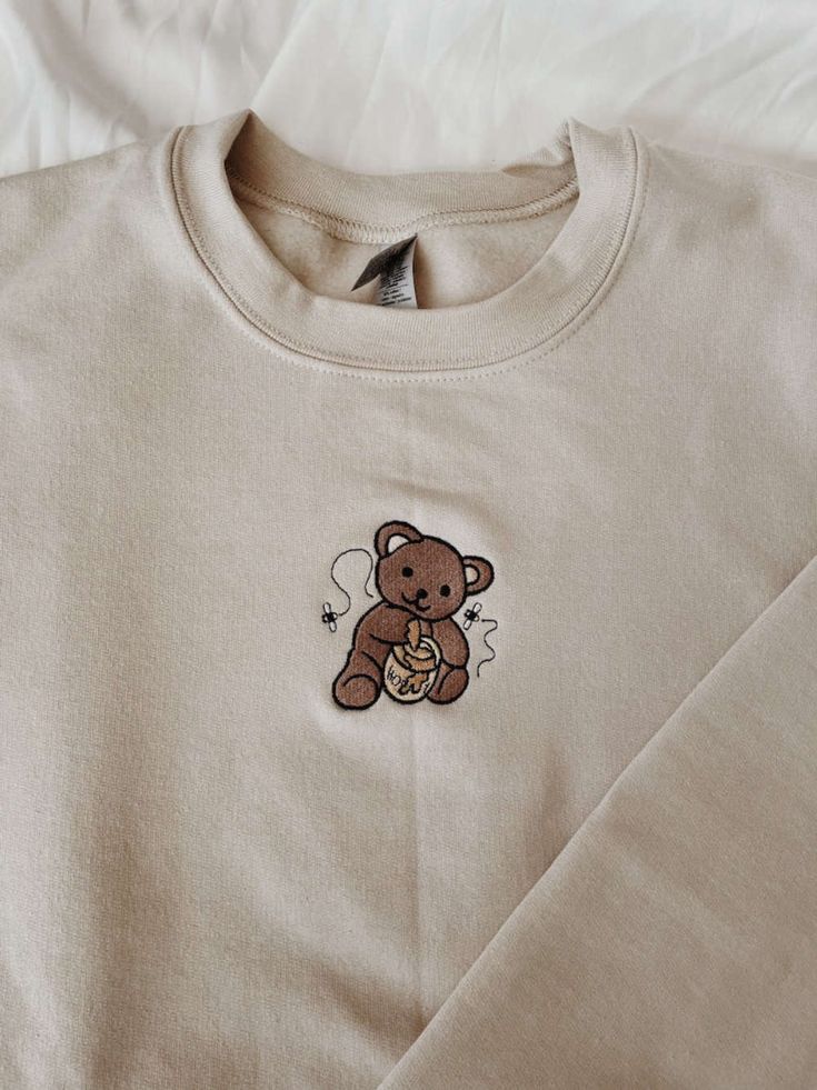 Introducing our Honey Bear Embroidered Sweatshirt 2D Crewneck Sweatshirt, a versatile and stylish clothing option for both women and men. This sweatshirt is designed to provide utmost comfort while making a fashion statement. Our Honey Bear Embroidered Sweatshirt features a unique 2D design, showcasing a charming honey bear embroidery on the front. This eye-catching detail adds a touch of playfulness and personality to your outfit, making you stand out from the crowd. Quality is our utmost prior Clothes Embroidery Diy, Bear Sweatshirt, Embroidery Hoodie, Honey Bear, Embroidery On Clothes, Cute Embroidery, Embroidery Sweatshirt, Sweatshirt For Women, Shirt Embroidery