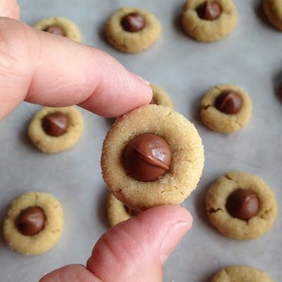 a hand is holding a chocolate chip cookie