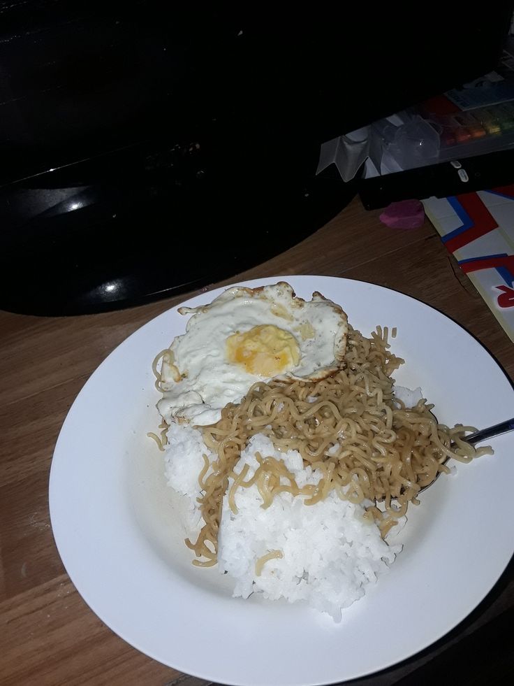 a white plate topped with rice and fried eggs