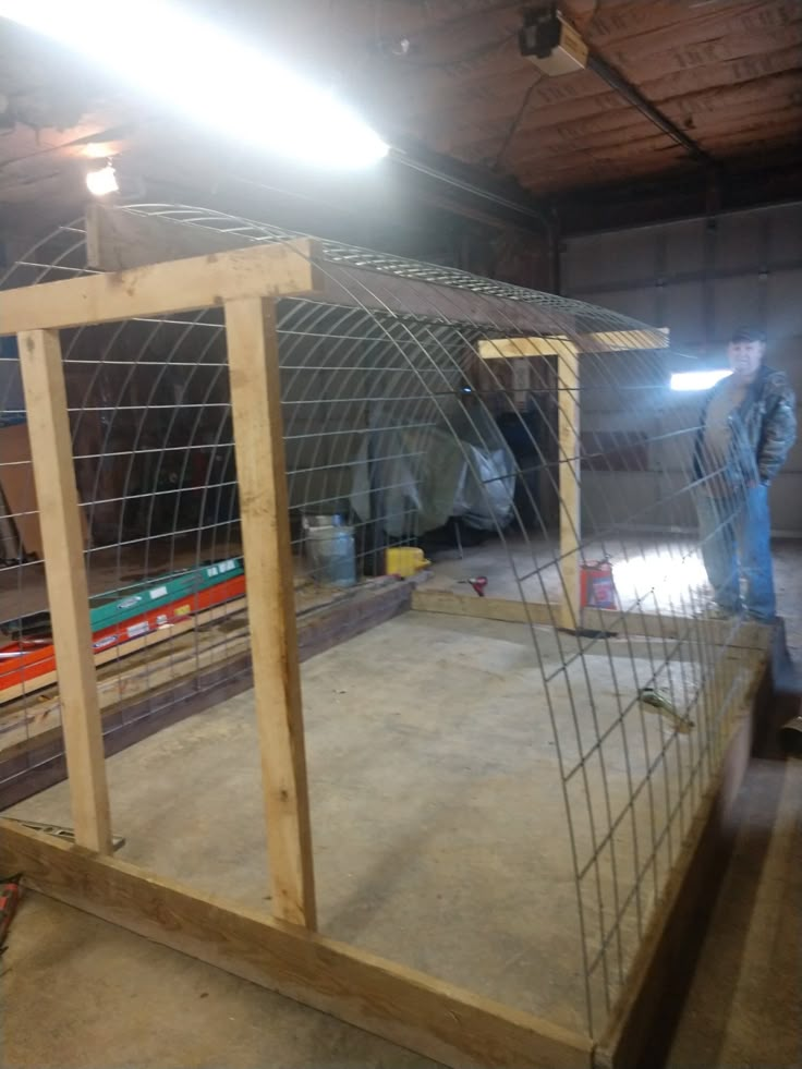 a man standing next to a cage in a warehouse