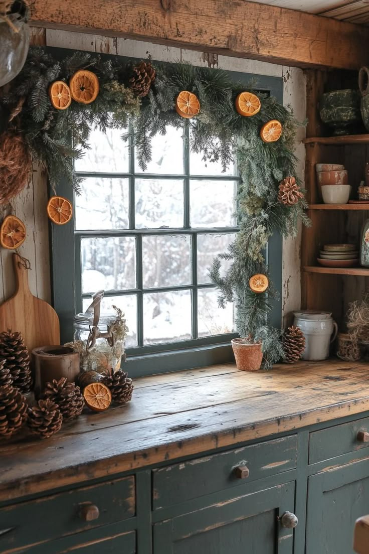 an old kitchen with pine cones and oranges on the windowsill is decorated for christmas