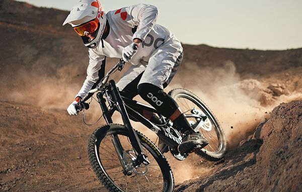 a man riding a bike on top of a dirt hill