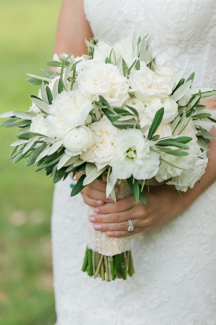 a bride holding a bouquet of white flowers