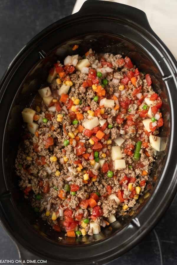 a crock pot filled with ground beef and vegetables