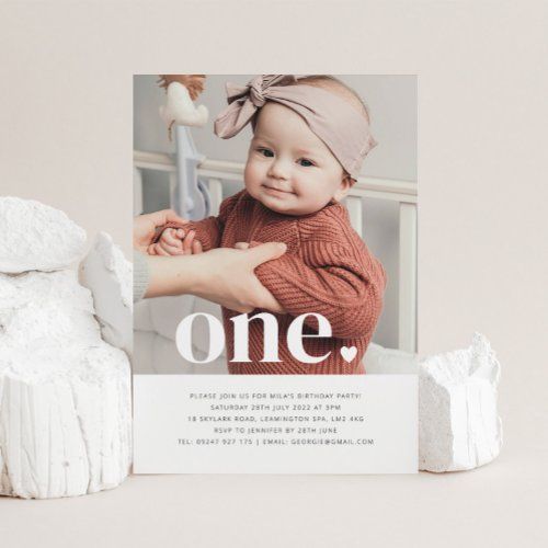 a white photo frame sitting on top of a table next to a piece of wood