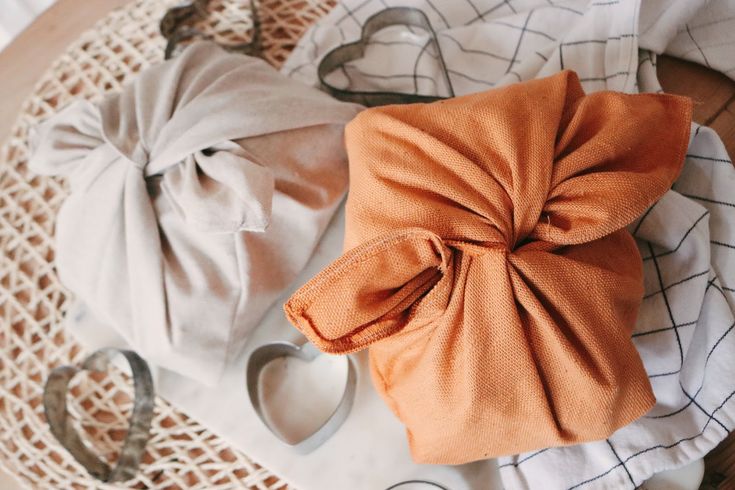 an orange bow sits on top of white napkins next to scissors and other items