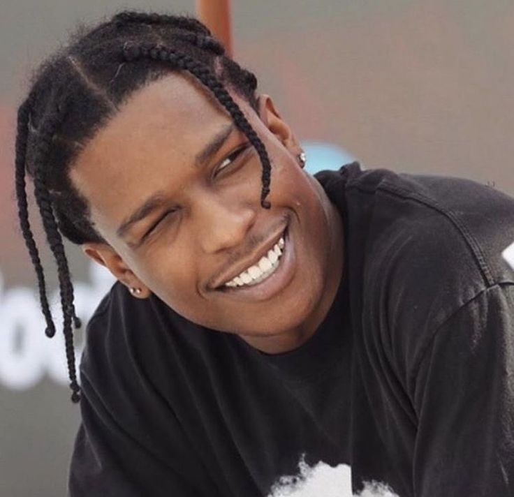 a young man with dreadlocks smiles at the camera