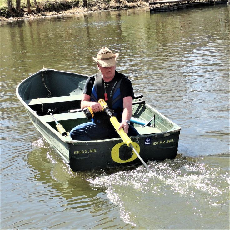 a man in a hat is rowing a small boat