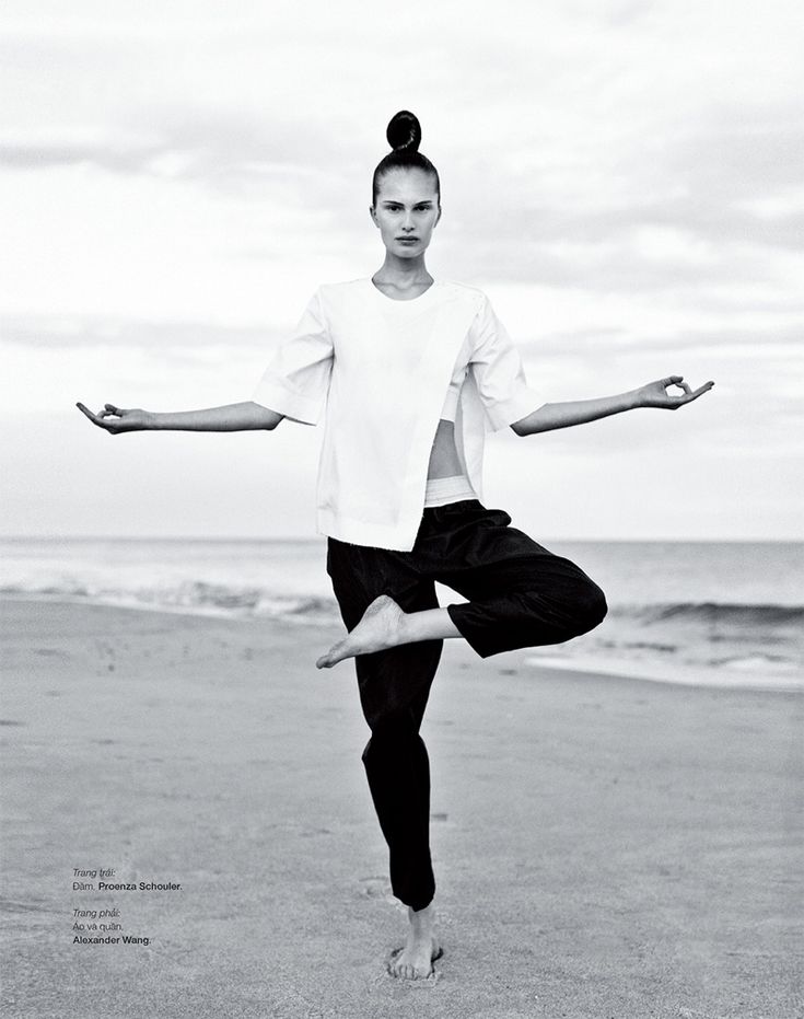 a woman is doing yoga on the beach