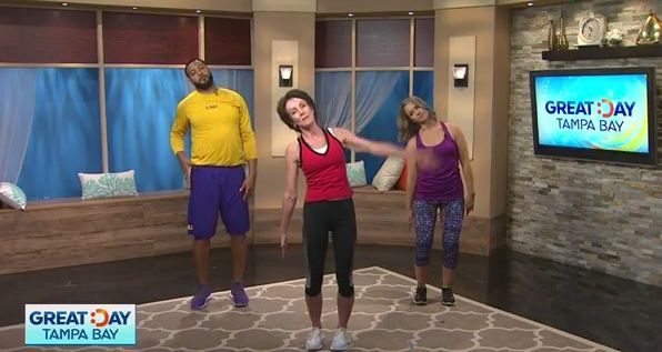 three people standing on a rug in front of a tv screen with the words great day tampa bay