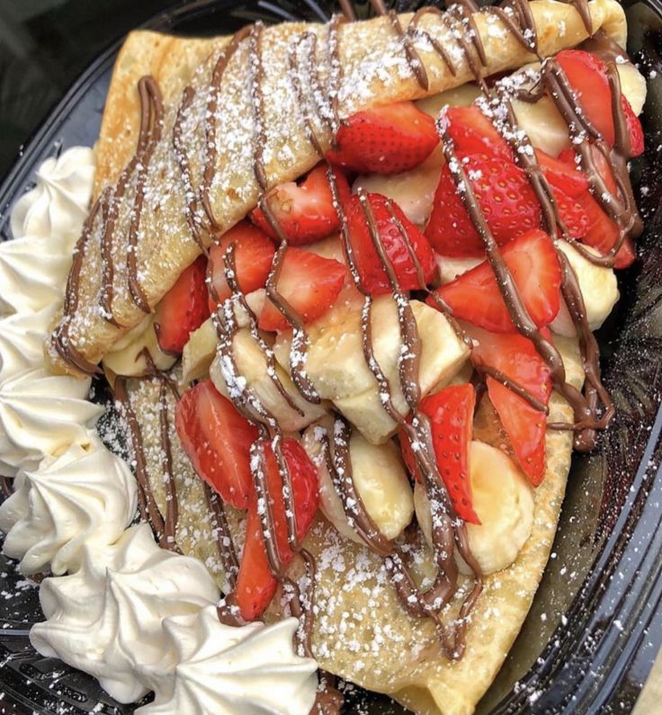 a pastry with strawberries and chocolate drizzled over it on a plate