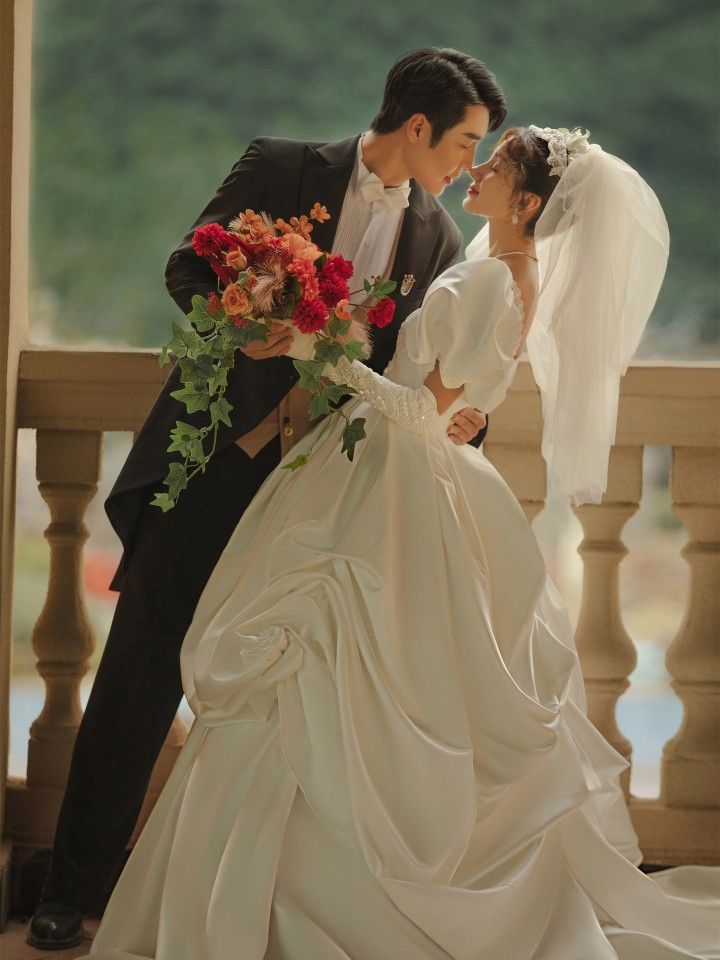 a bride and groom kissing on the balcony