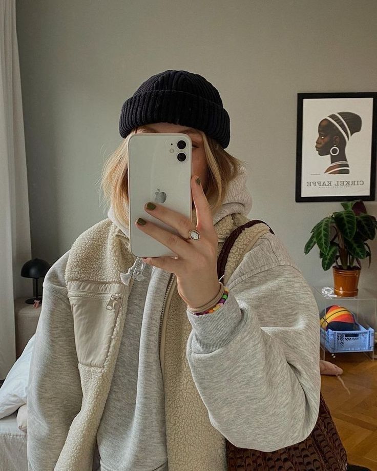 a woman taking a selfie with her cell phone in front of her face while sitting on a couch