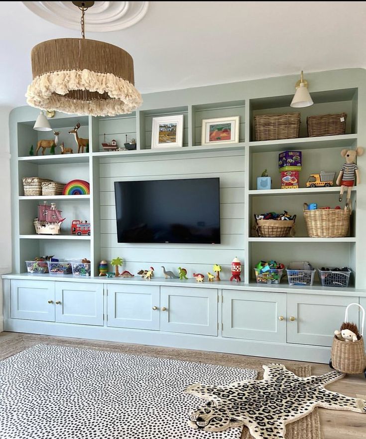 a living room filled with lots of furniture and a flat screen tv mounted on top of a wall