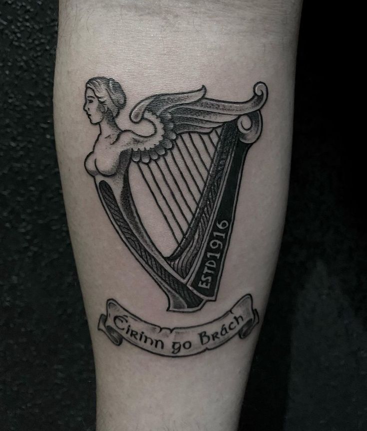 Depiction of an isish harp design. American Traditional Harp Tattoo, Northern Ireland Tattoo, Irish Traditional Tattoo, Guinness Harp Tattoo, Celtic Harp Tattoo, Traditional Irish Tattoos, Irish Heritage Tattoo, Guinness Tattoo, Irish Tattoo Ideas