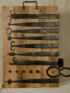 an old wooden board with many different types of scissors on it and a key hanging from the back