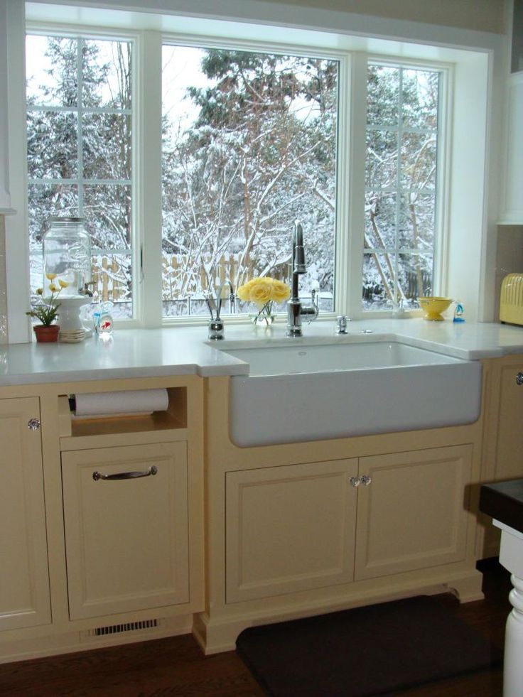 a white kitchen sink sitting under a window next to a stove top oven and dishwasher