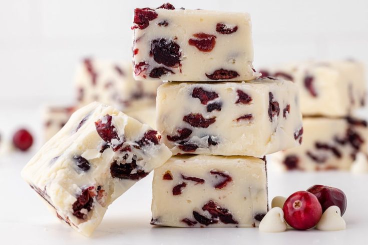 several pieces of white chocolate with raisins and nuts on a wooden cutting board