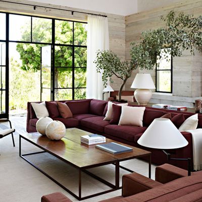 a living room filled with furniture and large windows