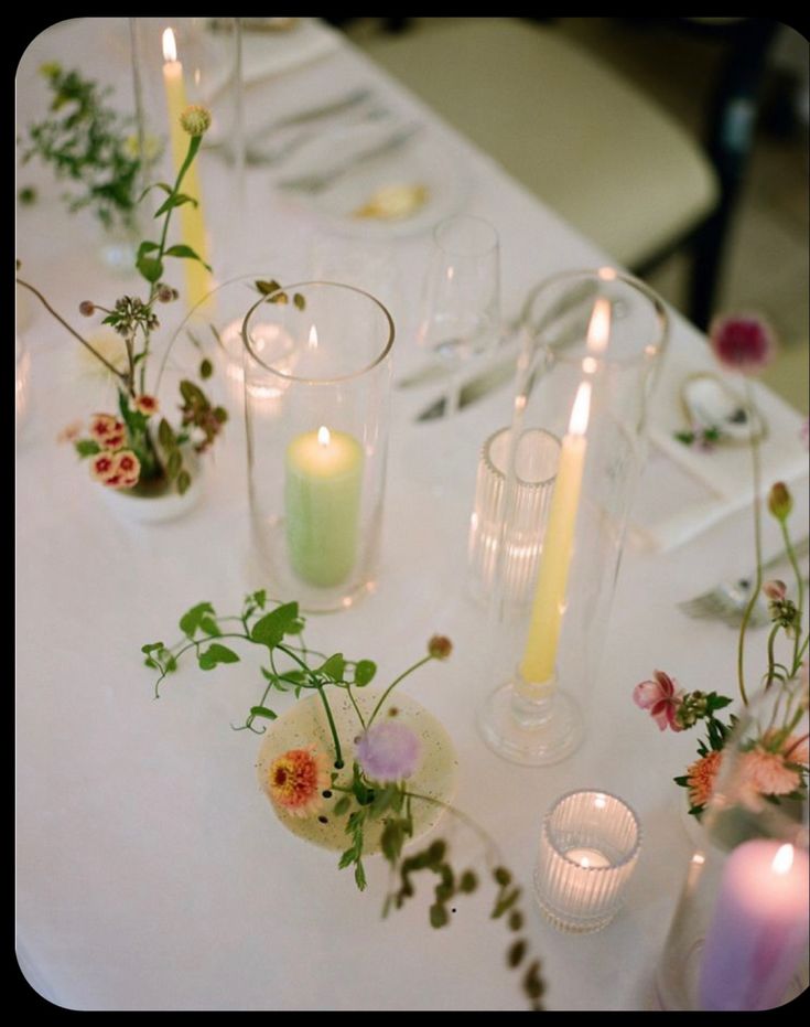 the table is set with flowers and candles