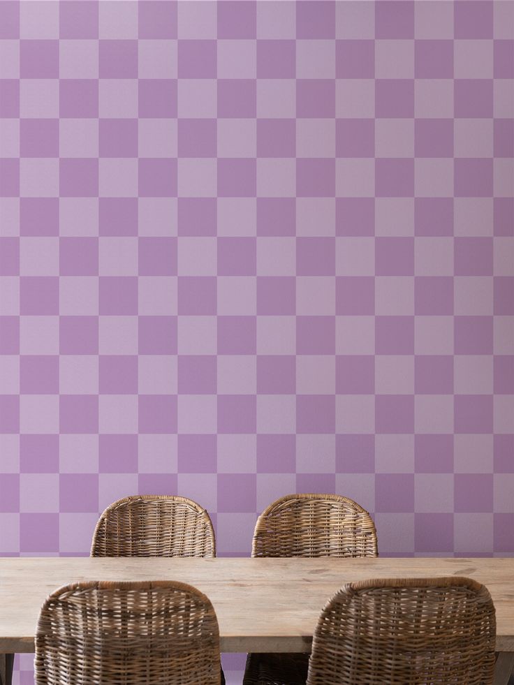 four wicker chairs sitting at a table in front of a purple checkered wall