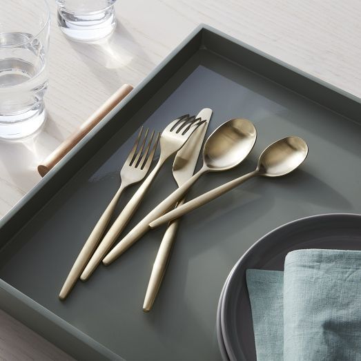 three forks, two spoons and one knife on a tray next to water glasses