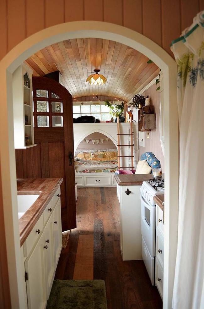 an archway leading to a kitchen with white appliances