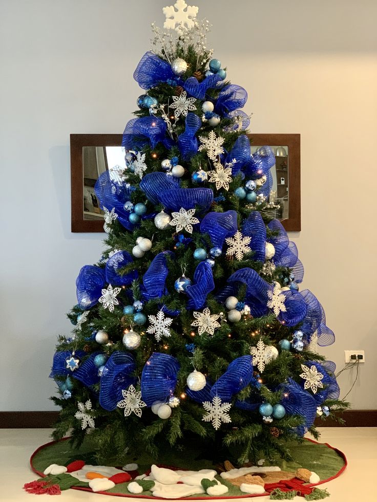 a blue christmas tree decorated with snowflakes