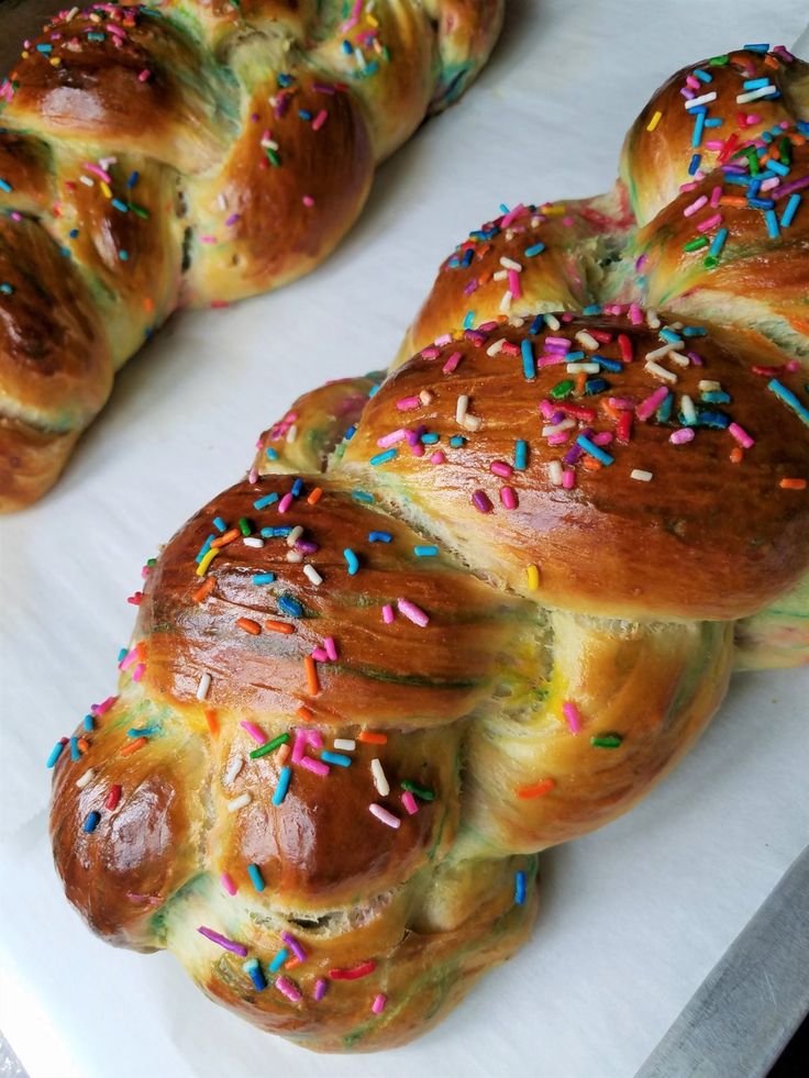 several braided breads with sprinkles on them sitting on a table