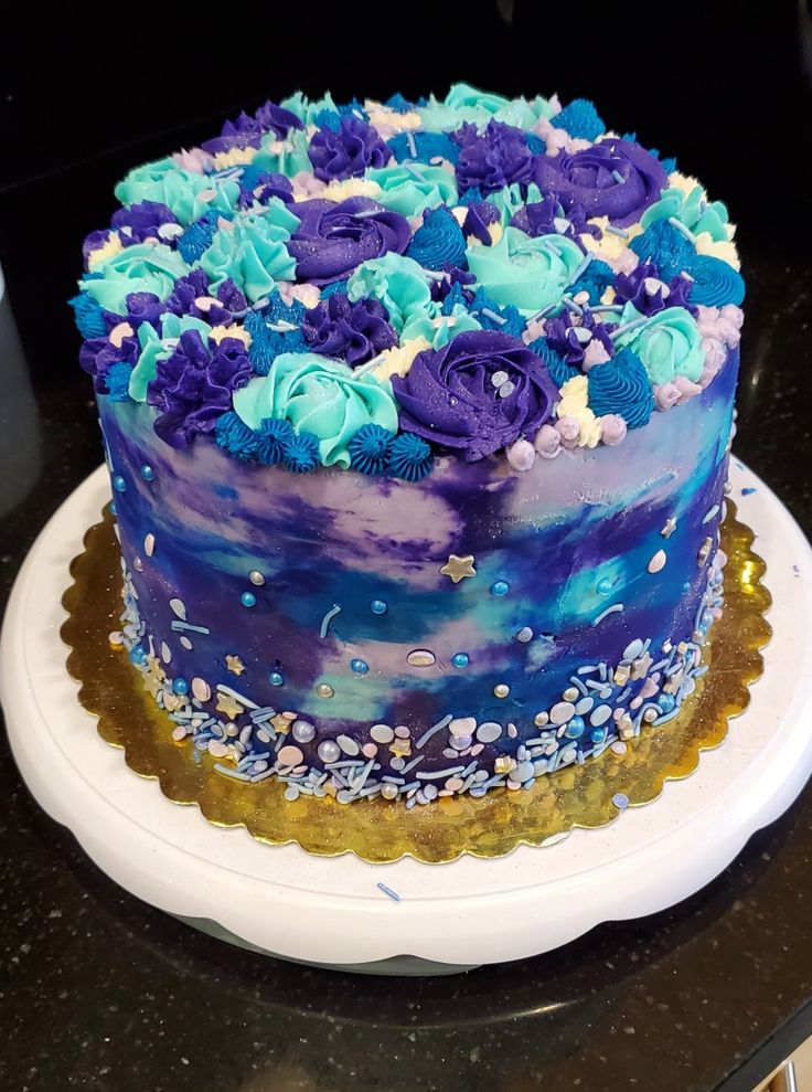 a blue and purple cake sitting on top of a white plate